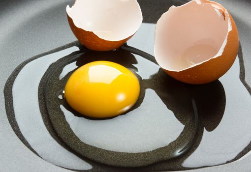 Egg with shell in frying pan
