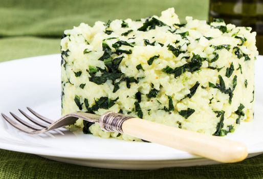 Spinach rice on white plate with vine