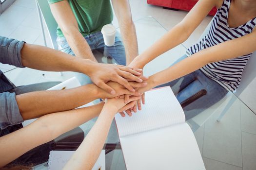 Fashion students putting hands together at the college