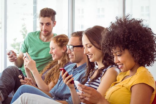 Fashion students looking at their smartphone at the college