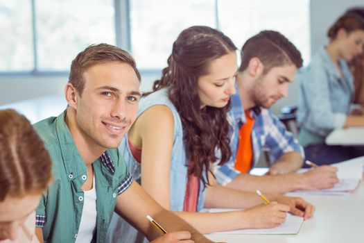 Fashion student smiling at camera in class at the college