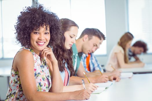 Fashion student smiling at camera in class at the college