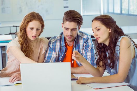Fashion students looking at laptop at the college 