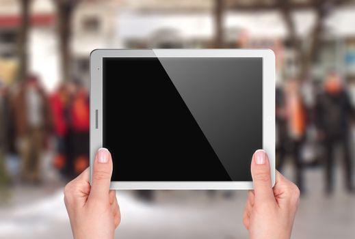 Tablet with blank screen in hand on background of street