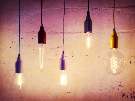 Illuminated light bulbs on concrete wall background. Industrial design. 