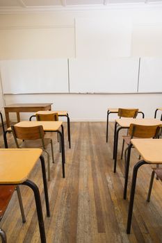 Empty classroom with empty chairs and desks