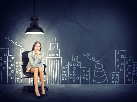 Young Businesswoman Sitting on Office Chair and Thinking Underneath Overhead Light in front of Illustration of City Skyline in Decision Making Concept Image