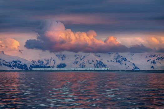 The Midnight sun over the icebergs of the Drake Passage near the Antarctic Peninsula in Antarctica. 