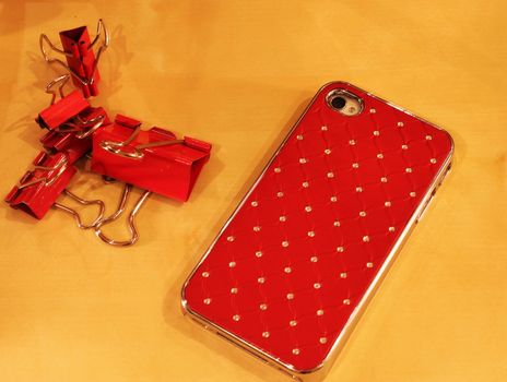 Cell phone and a clothespin for papers in red color scheme