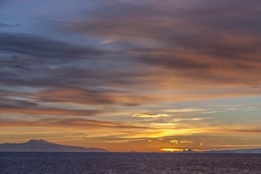 The Midnight sun over the icebergs of the Drake Passage off the coast of the Antarctic Peninsula in Antarctica. 