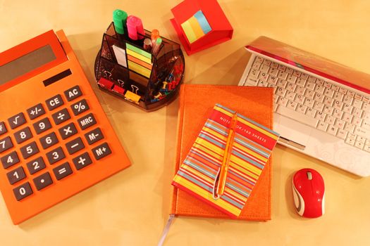 Calculator, daily planner and orange colored stationery