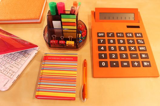 Calculator, daily planner and orange colored stationery