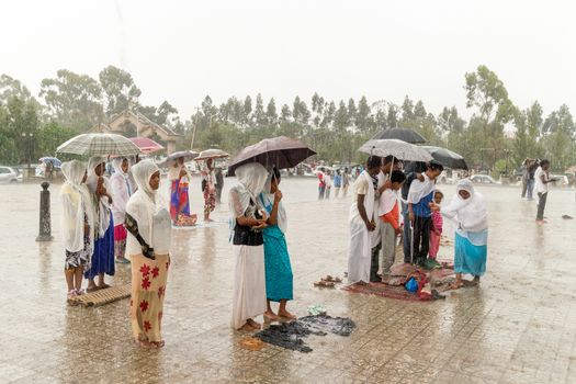 Addis Ababa: April 10: Devoted Ethiopian Orthodox followers stand undeterred by the pouring rain to observe Siklet, the crucifixion of Jesus Christ, at Bole Medhane Alem Church on April 10 ,2015 in Addis Ababa, Ethiopia