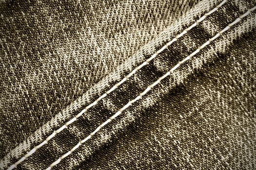 part of old jeans background with diagonal seams. monochrome image