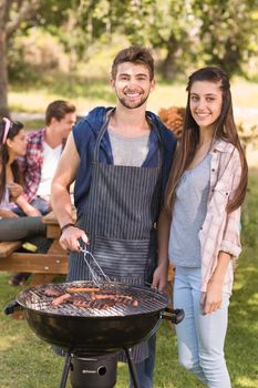 Happy friends in the park having barbecue on a sunny day