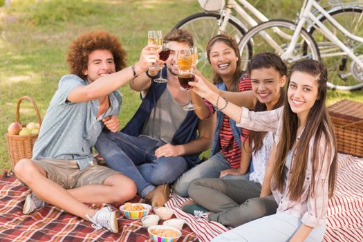 Happy friends in the park having picnic on a sunny day