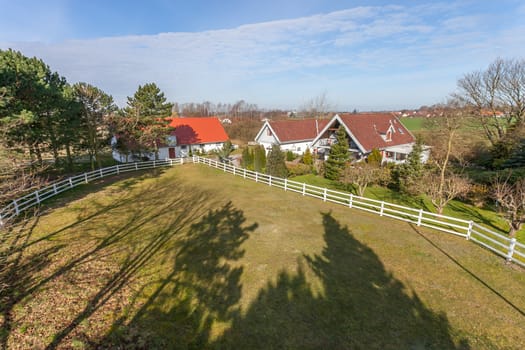 Traditional danish farm house and horse paddock in the sunshine