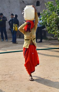 Jaipur, India - December 30, 2014: Local women carry their everyday load on their head on December 30, 2014 in Jaipur, India. Using a head is an efficient way to leave hands free for other luggage