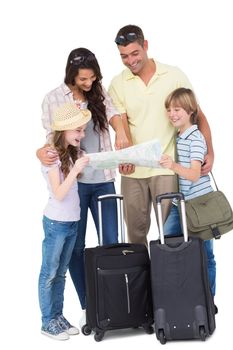 Happy family with luggage exploring map over white background