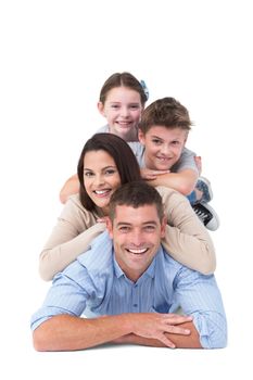 Portrait of happy family lying on top of each other over white background