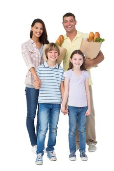 Portrait of happy family with grocery bags over white background