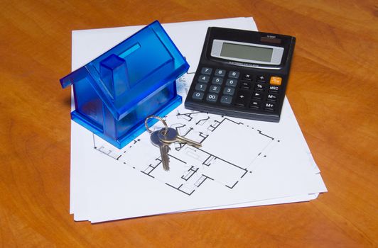 Toy house and calculator on table