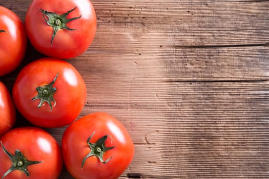 Close up Fresh Organic Red Tomatoes Placed on Top of a Wooden Market Table with Copy Space for Texts. Captured in High Angle View.