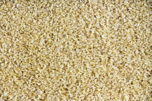 Background texture of cracked wheat which has been crushed or cut to reduce cooking time of the seeds or grains