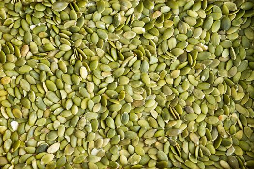 Background texture of fresh healthy green de-husked pumpkin seeds a popular snack and salad ingredient rich in protein and nutrients