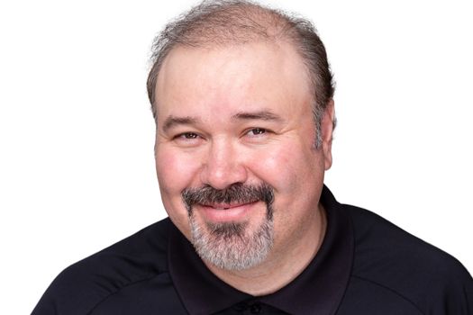 Smiling genial middle-aged man with a jovial expression beaming at the camera, head and shoulders isolated on white