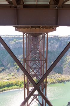 View looking along the metal supports of the span underneath the old Perrine Bridge as it crosses the Snake River Canyon near Twin Falls in Idaho showing the metal lattice structure