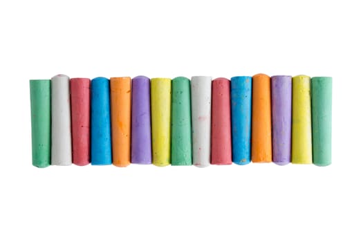 Long row of brightly colored chalk crayons in the colors of the rainbow neatly aligned centered on a white background , view from above