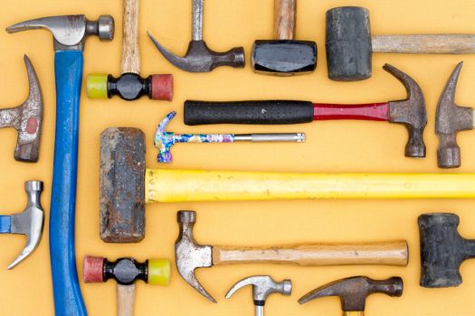 Display of a diversity of hammers in a tool kit for DIY, carpentry, construction, mallets and a sledgehammer in a neat arrangement on a wooden table, overhead view