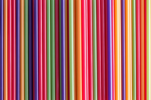 Full frame abstract background of colorful plastic drinking straws in the colors of the rainbow or spectrum for a festive occasion or party concept