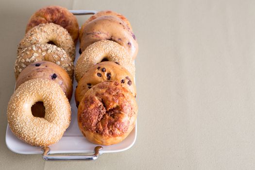 Fresh Bagel Breads, Good for After Office Meeting Snacks, Prepared on a White Tray Placed on a Table with Copy Space.