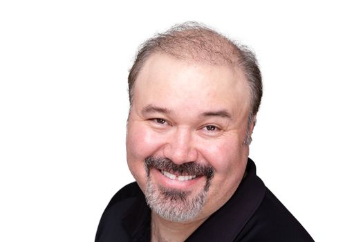 Genial middle-aged man with a beaming friendly smile standing sideways turning to look at the camera, close up head shot on white