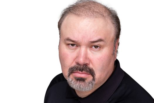 Implacable overbearing middle-aged man looking at the camera with a stern expression and baleful glare, head and shoulders isolated on white