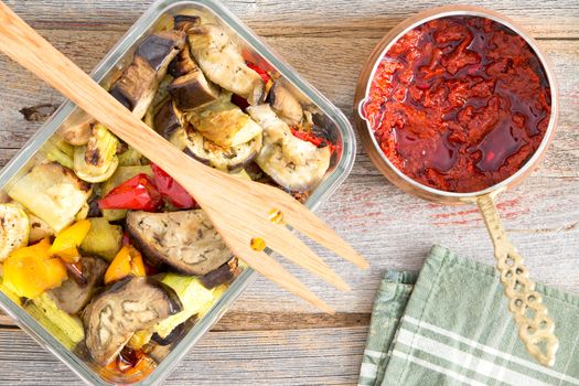 Healthy roast or grilled Turkish style vegetables served with zucchini, eggplant and sweet peppers served with a bowl of piquant hot spicy pepper paste, overhead view