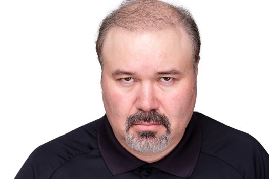 Dour angry middle-aged man glowering at the camera from under his brows, head and shoulders isolated on white