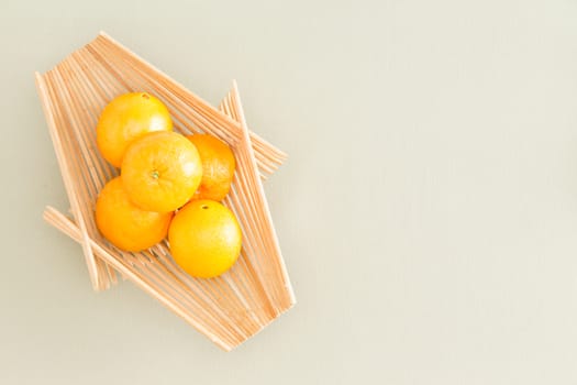 Healthy Fresh Orange Fruits on a Wooden Tray Place at the Table with Copy Space. Captured in High Angle View.