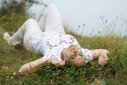 Woman laying in the grass on the meadow