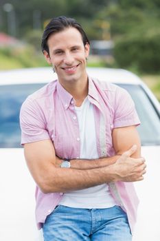 Man smiling at camera outside his car