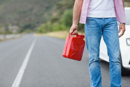 Man holding petrolcan at the side of the road