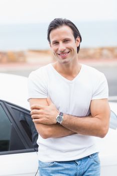 Smiling man leaning on the door of his car