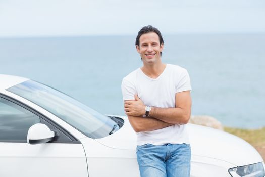 Man smiling at camera outside his car