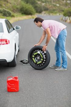 Man changing wheel after a car breakdown at the side of the road