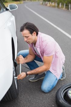 Man changing wheel after a car breakdown at the side of the road