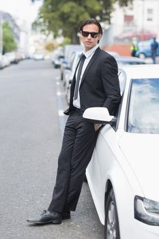 Businessman leaning on the door of his car