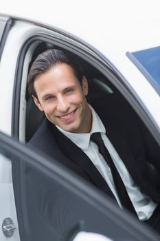 Businessman smiling at camera in his car