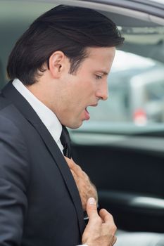 Businessman having a heart attack in his car